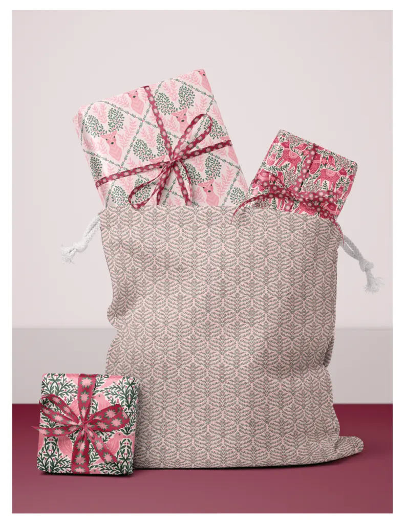 A festive fabric bag filled with wrapped gifts in red, pink, and green designs featuring deer and foliage patterns.
