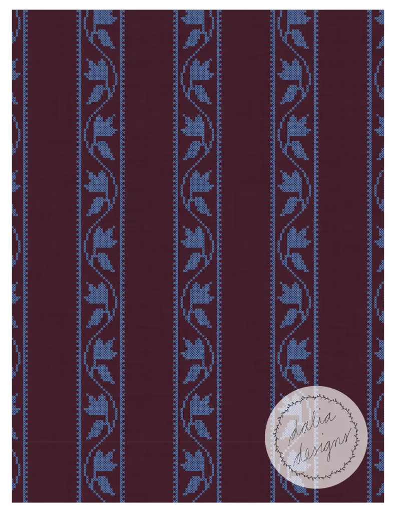 Burgundy red fabric with a cross-stitch pattern featuring blue flowers and leaves, arranged in vertical stripes.
