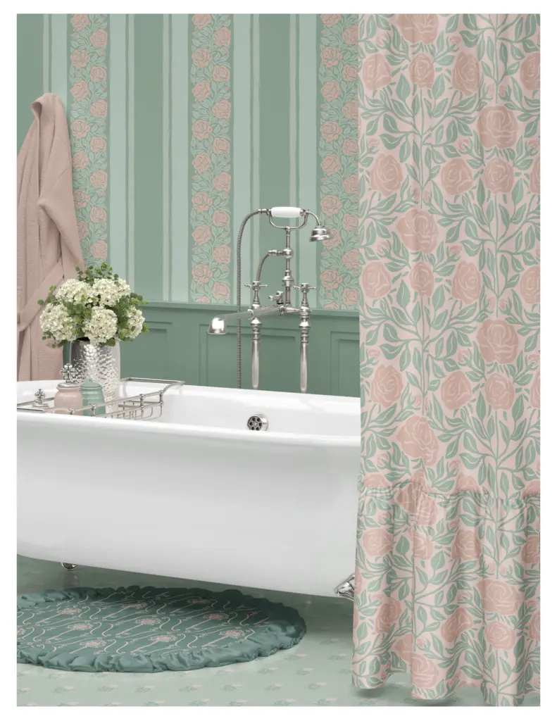 A stylish bathroom featuring a vintage clawfoot bathtub, pastel green walls with floral patterns, a floral shower curtain, a decorative rug, and a vase of white flowers.