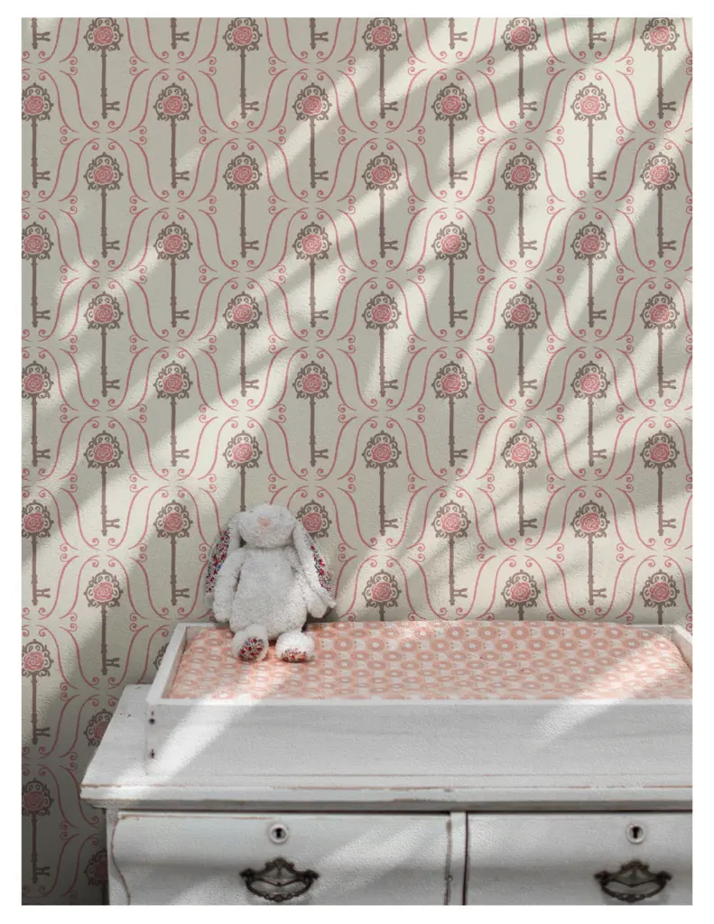 A vintage nursery scene featuring a patterned wallpaper with keys and roses, and a stuffed bunny placed on a dresser with a pink patterned changing pad.