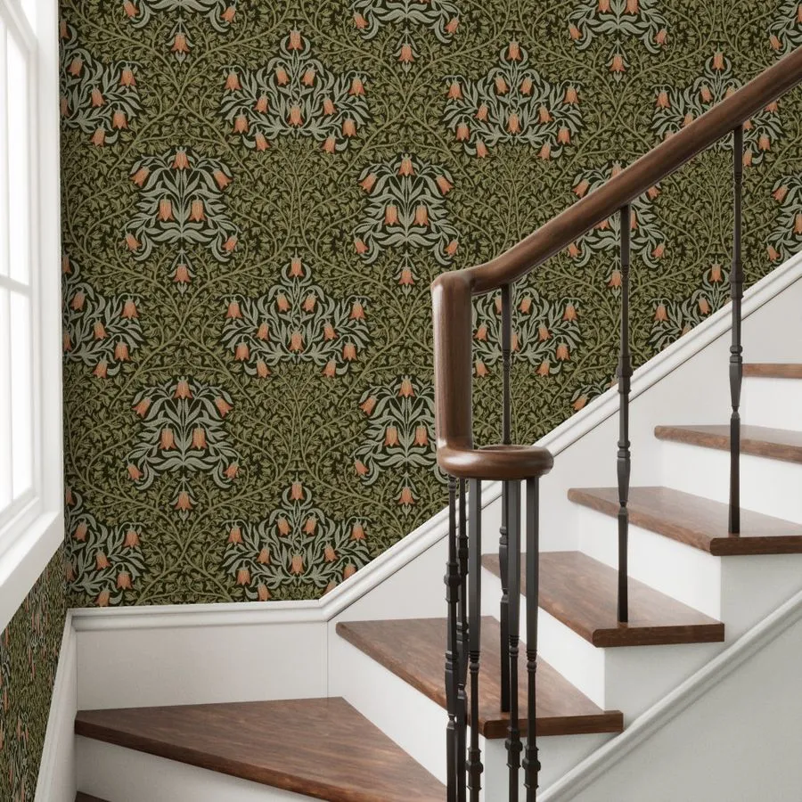 A wooden staircase leading up, with an ornate green and floral wallpaper on the wall, featuring accents of coral and cream.